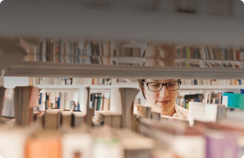 woman looking through books at a library