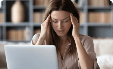 Woman taking glasses off and experiencing a migraine