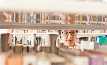 woman looking through books at a library