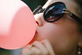 women blowing a bubble with chewing gum