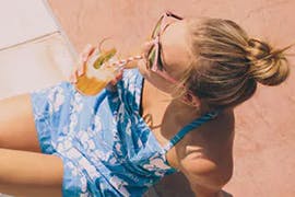 women in the sun drinking a drink 