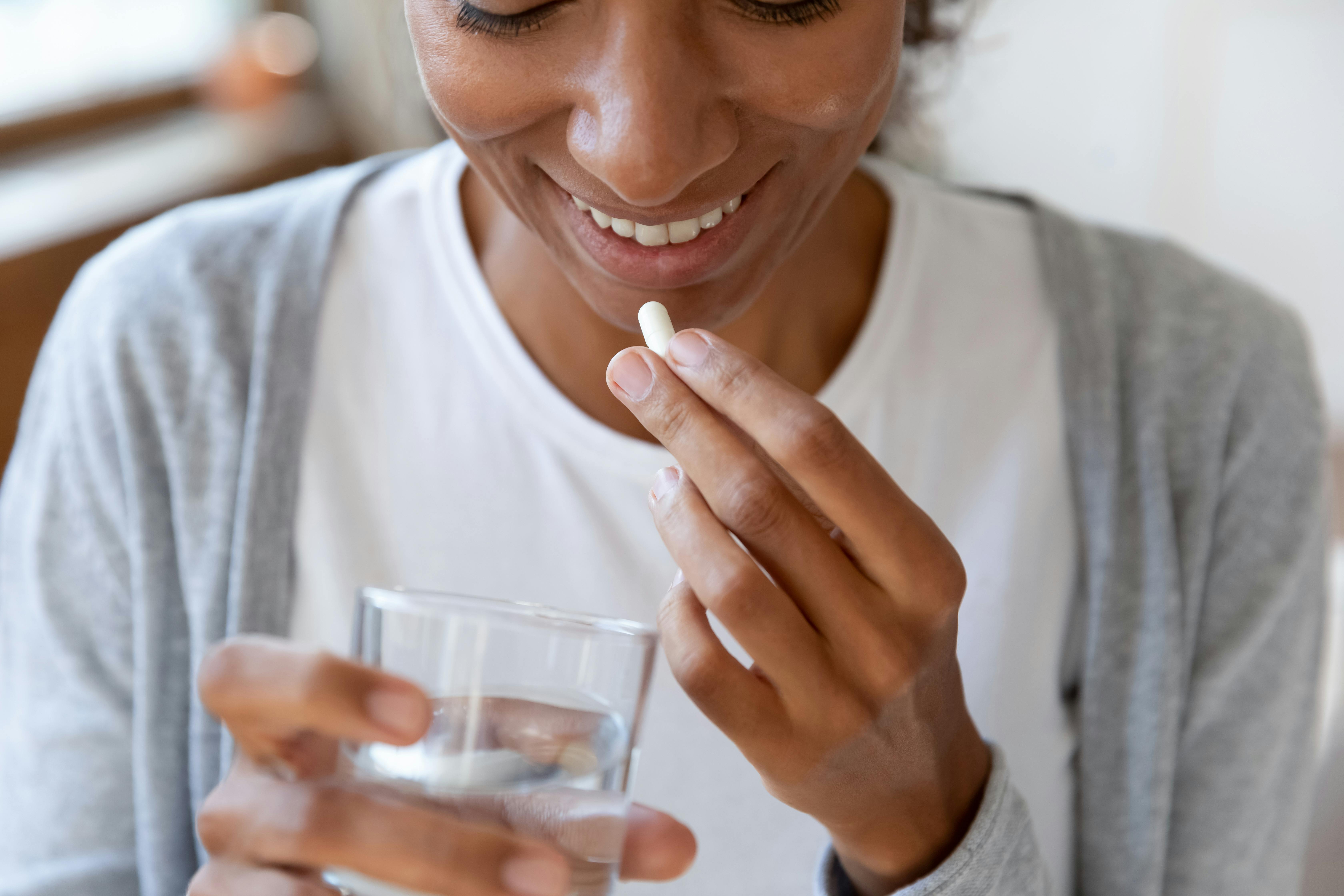 Smiling woman taking a pill