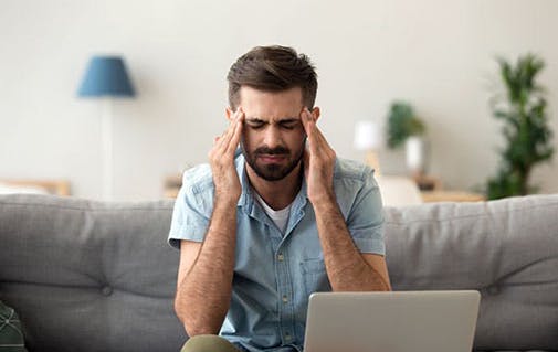 Man rubbing head with a headache