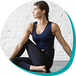 a young brunette woman stretching in a yoga pose while wearing yoga athletic clothing