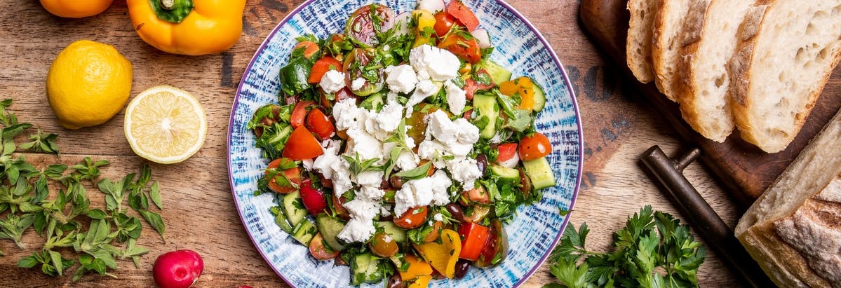 A plate of Mediterranean food on a wooden table