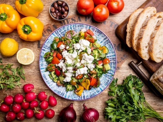 A plate of Mediterranean food on a wooden table