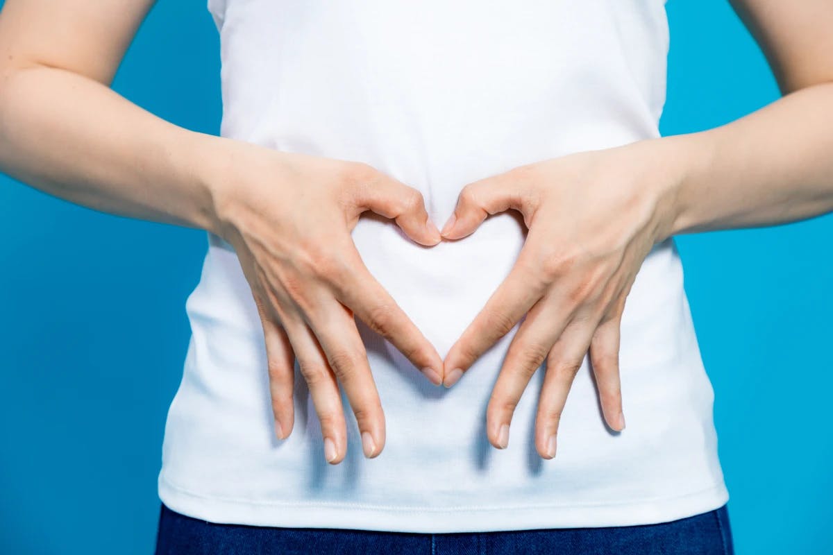 Woman making a heart over her stomach