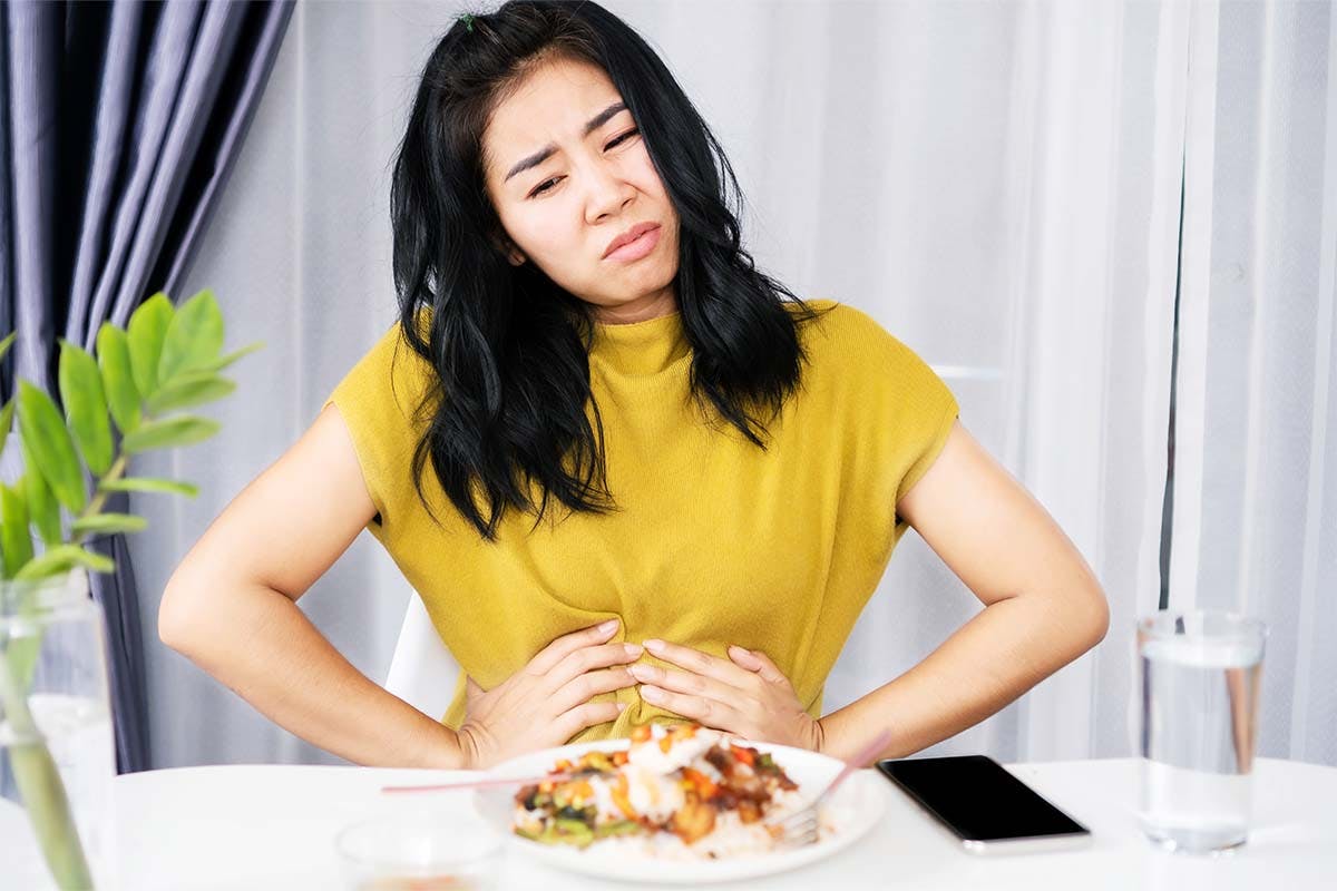 woman eating spicy food feeling sick