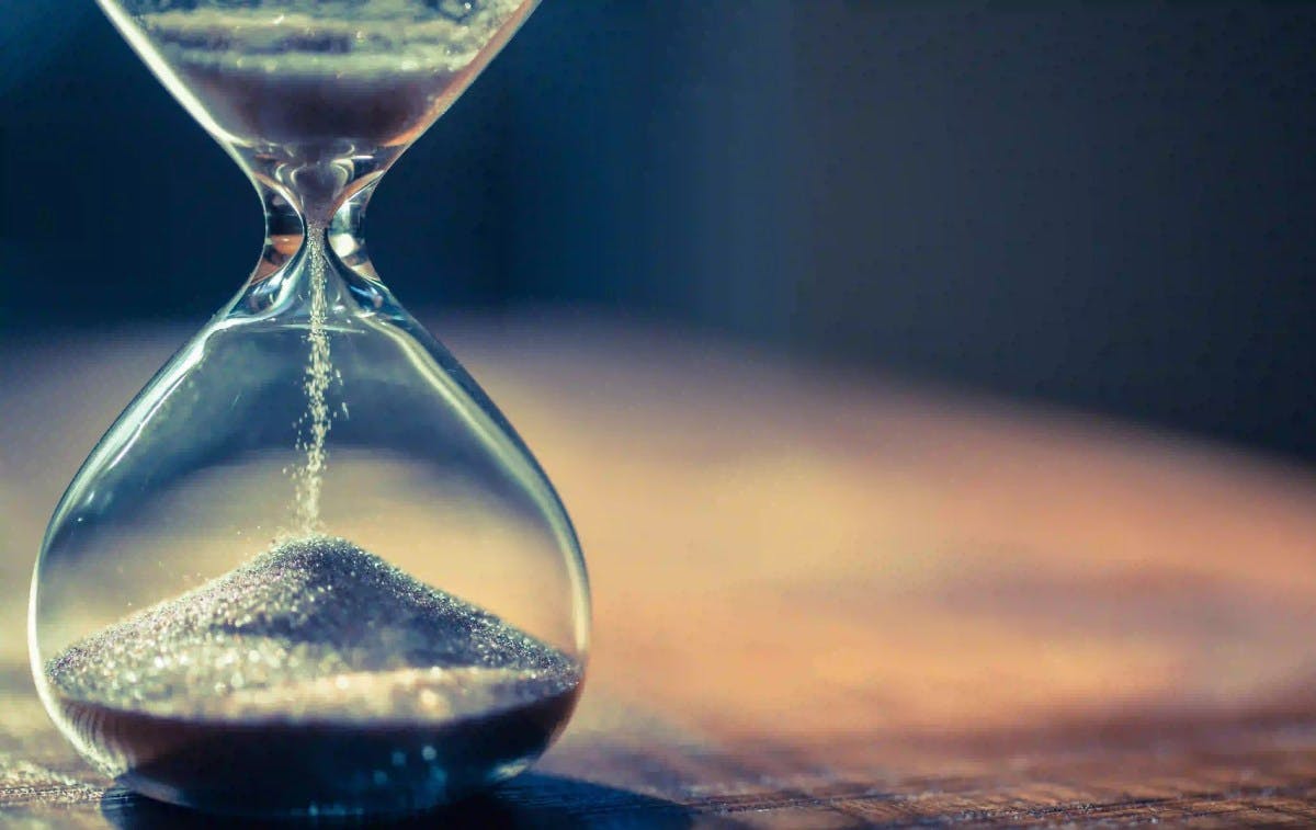 sand running in an hourglass that measures time passing