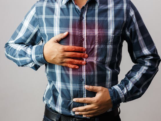 Man holding hand to chest with symptoms of burning sensation