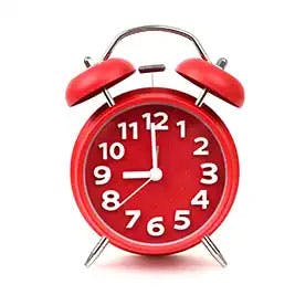 Reloj despertador rojo cerca de la medicina