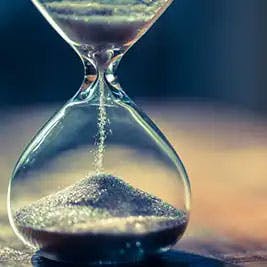 sand running in an hourglass that measures time passing