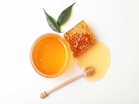 Vista de panal de miel y miel sobre fondo blanco