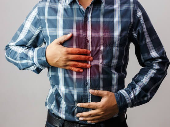 Hombre sosteniéndose el pecho con síntomas de sensación de ardor