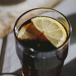 A glass of soda with a lemon in it