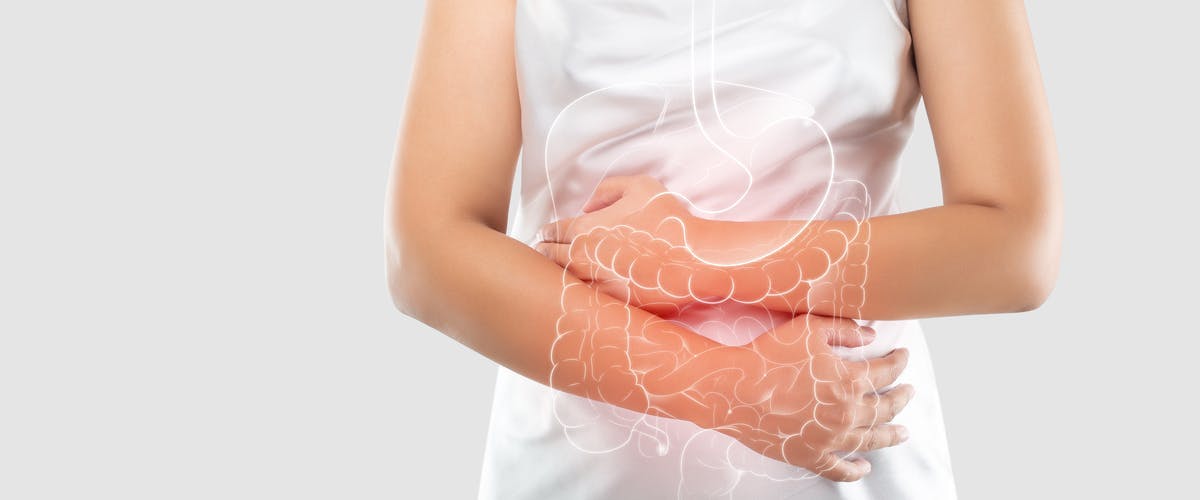 Mujer sosteniendo su estómago debido a dolor intestinal