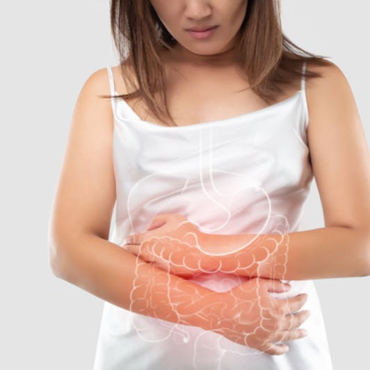 Mujer sosteniendo su estómago debido a dolor intestinal