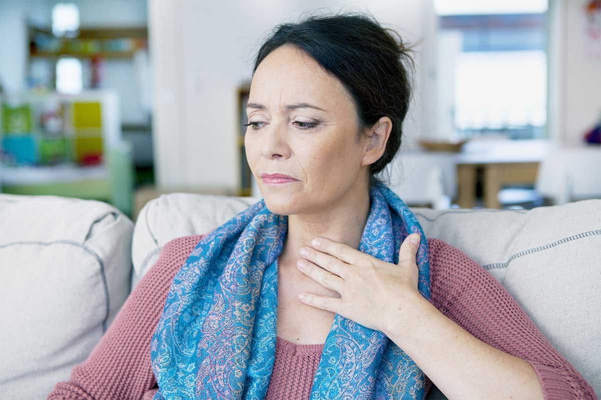 Mujer en la cama con dolor de garganta