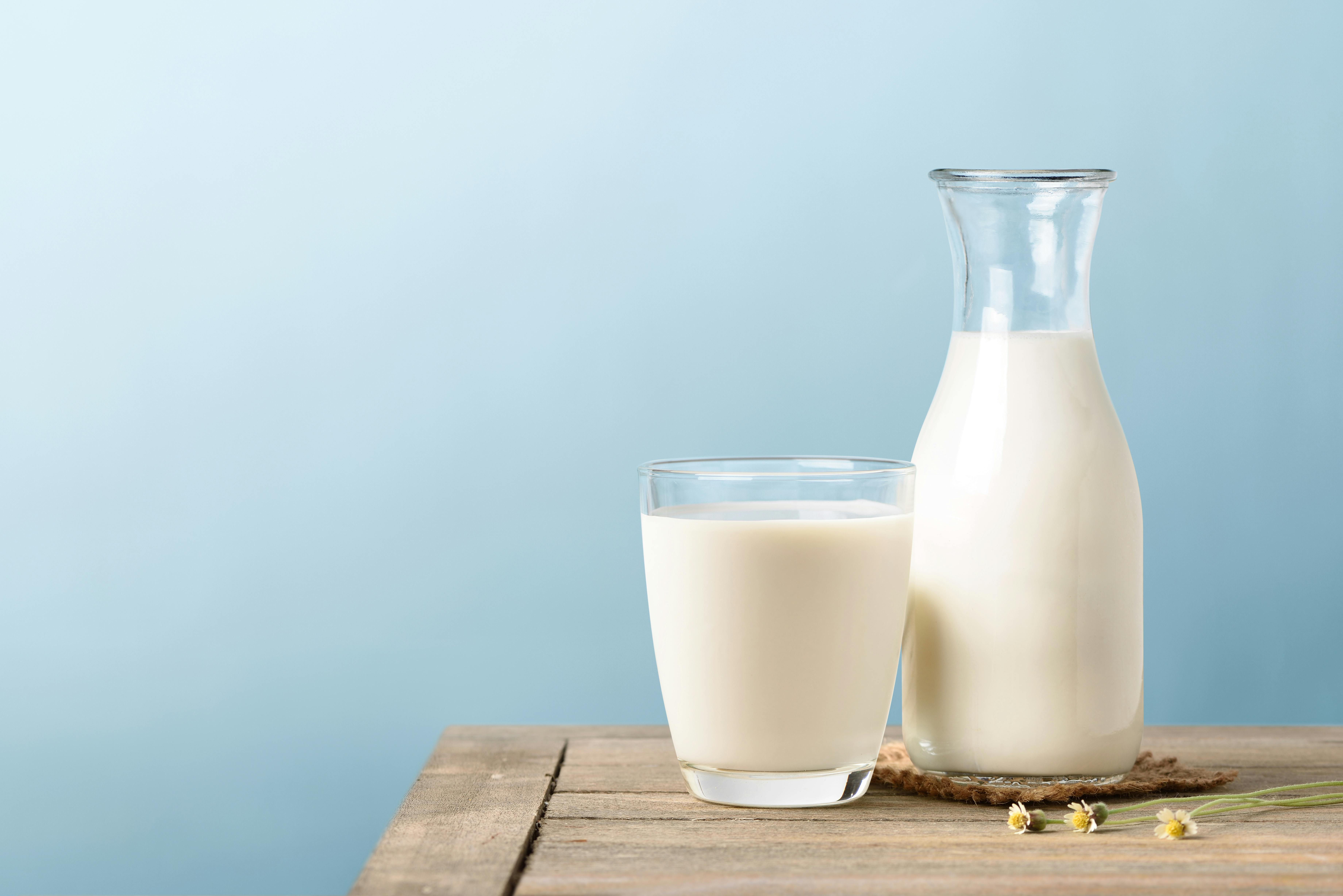 Glass of milk and bottle of milk on wooden table Glass of milk and bottle of milk on wooden table