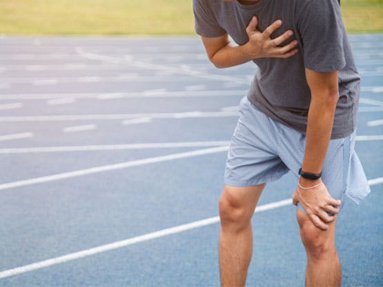 Man holding his chest after running