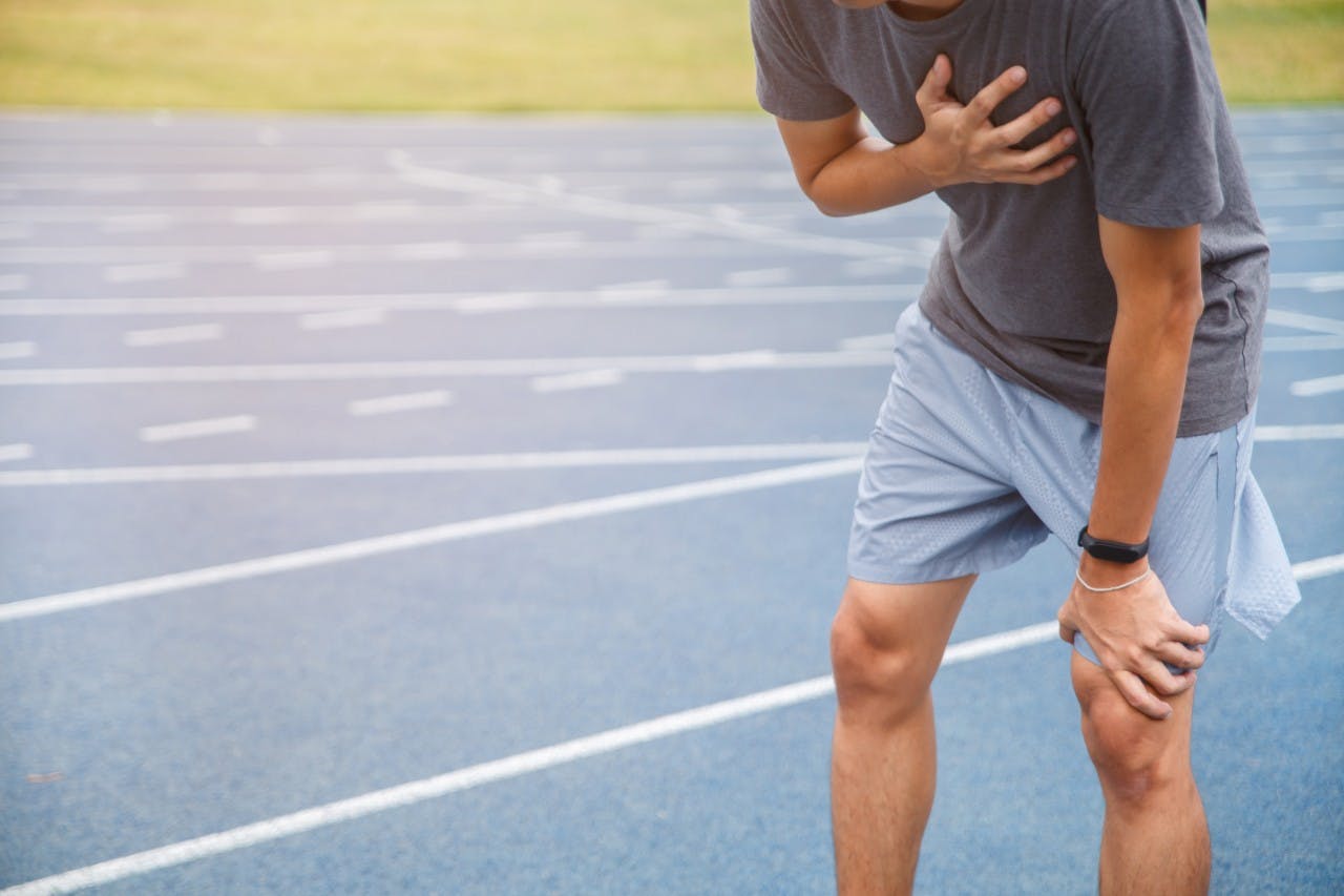 Man holding his chest after running