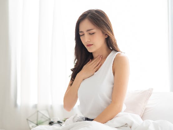 Woman waking up with acid reflux