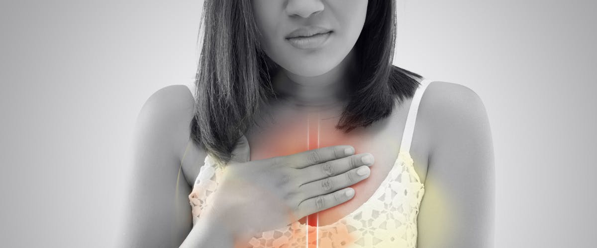 A woman experiencing acid reflux or heartburn.
