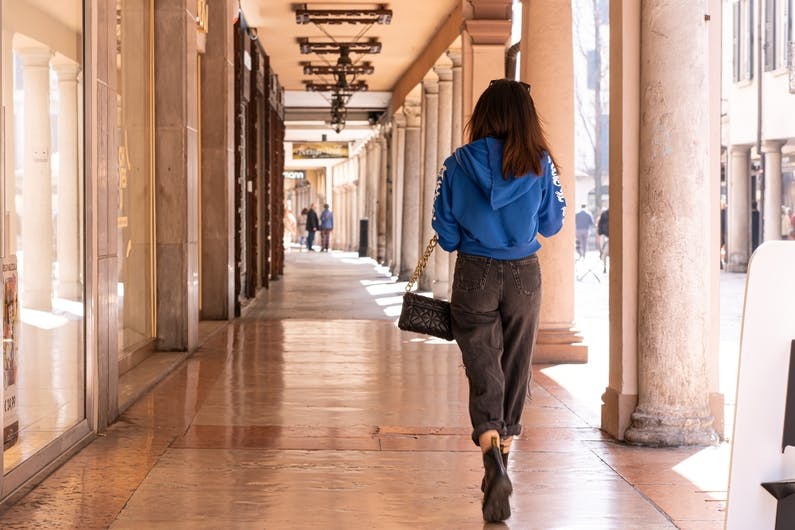 woman walking away through shopping street