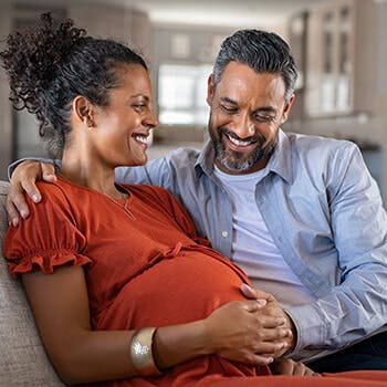 Man embracing pregnant woman’s belly