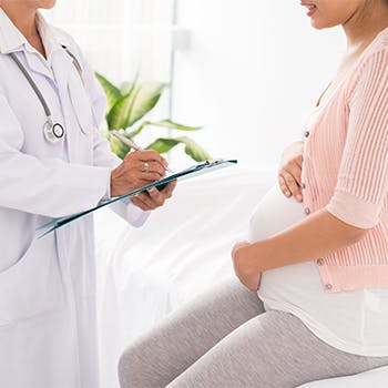 Pregnant woman talks to doctor 