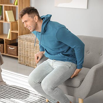 Man holding onto butt from seat