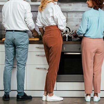 3 personas de pie en la cocina
