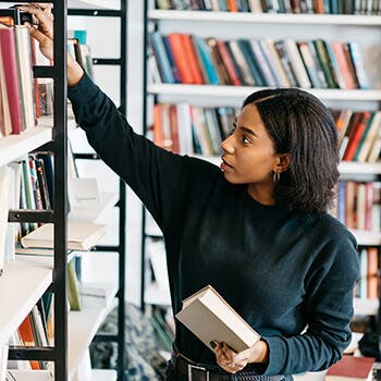 Persona sacando un libro del estante