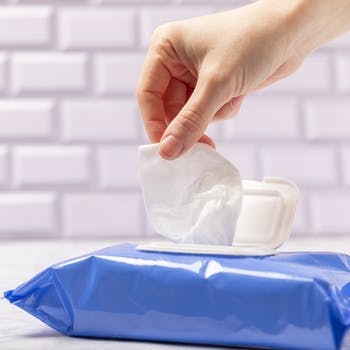 Wipe being removed from a blue package