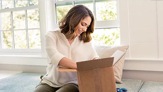 Woman smiling while unboxing something