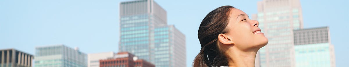 woman taking deep breath in city