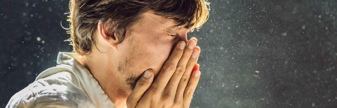 Man surrounded by air pollution sneezes Man surrounded by air pollution sneezes
