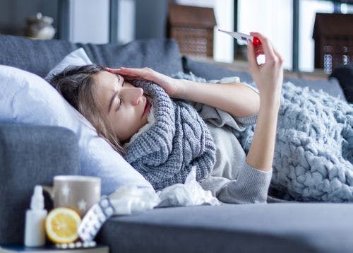 Sick woman on the couch has a fever Sick woman on the couch has a fever
