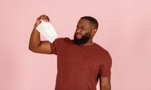 A disgusted man holding a tissue