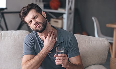 Man experiencing throat pain