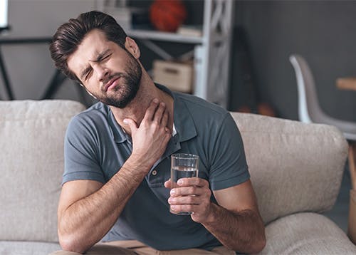 Man experiencing throat pain