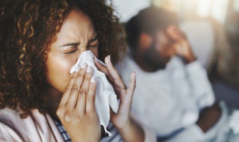 Woman blows her nose into a tissue