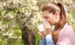 Girl sneezing into a tissue