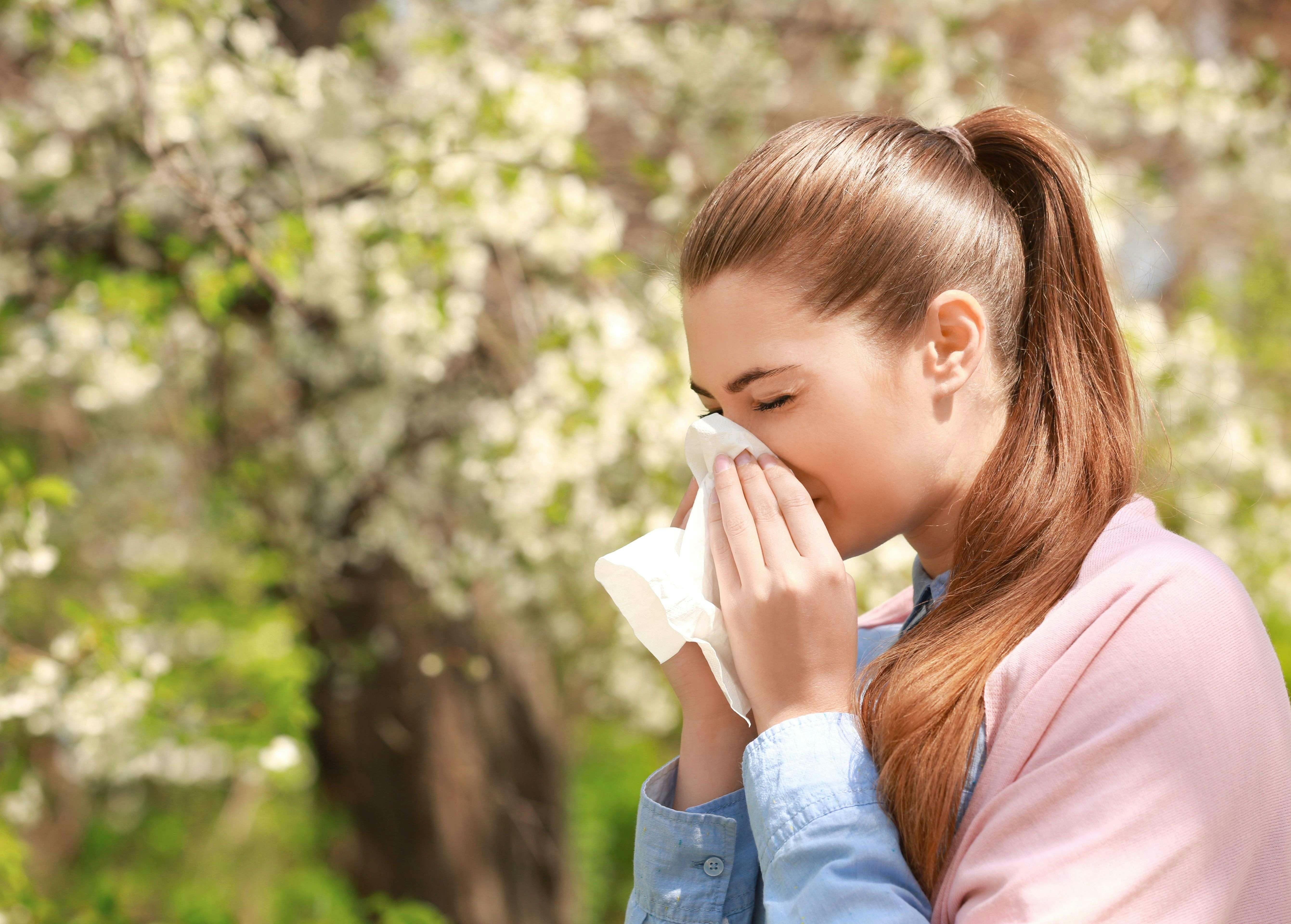 Girl sneezing into a tissue