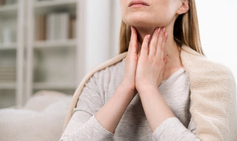 A woman massaging her throat