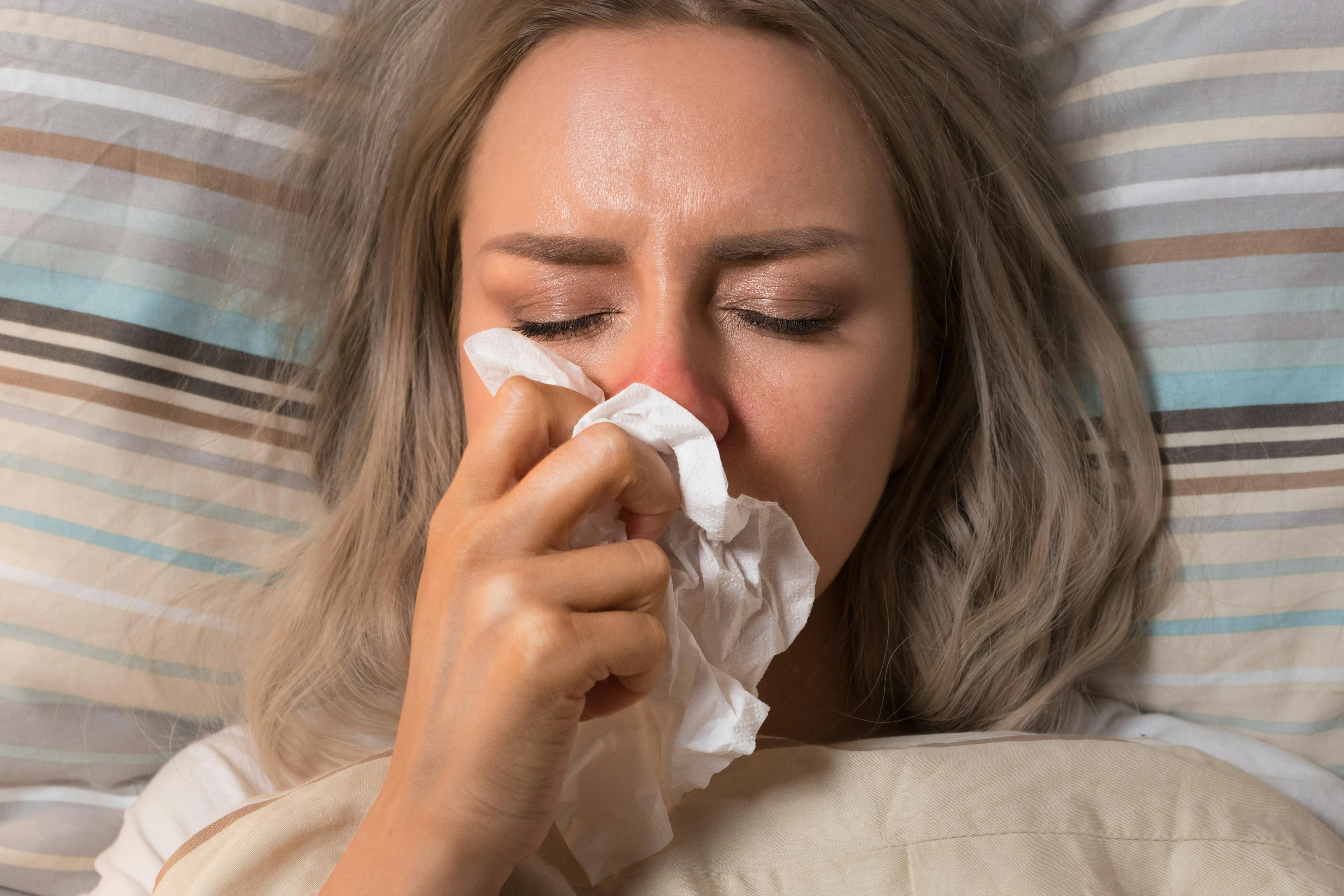 A woman trying to relieve her stuffy nose while she’s lying down