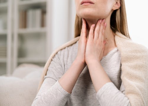 A woman massaging her throat