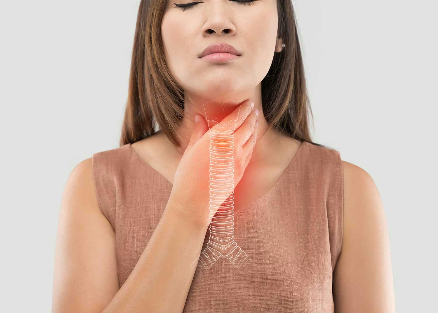 Woman holding her throat with 3-D image of trachea and bronchial tubes.