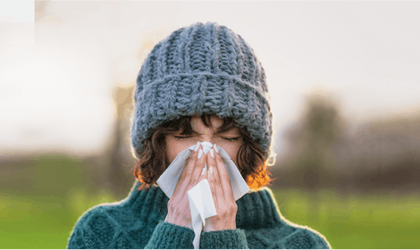 Women blowing nose into a tissue