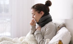 Young woman coughing and holding chest